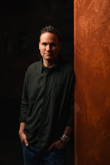 A man standing in a dark space looking at the camera
