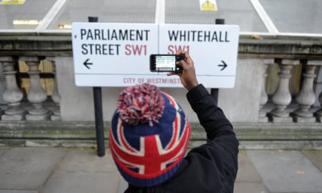 A tourist photographs the Parliament/Whitehall street signs.
