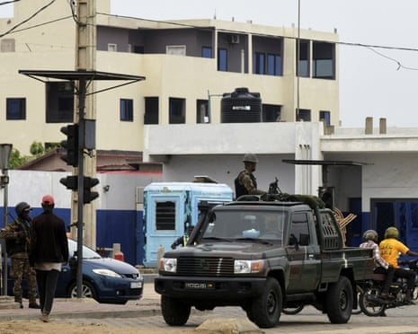 Soldiers in a military vehicle on a busy street