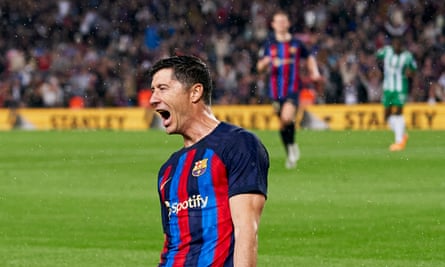 Robert Lewandowski slides on his knees across the pitch to celebrate his goal for Barcelona against Betis.