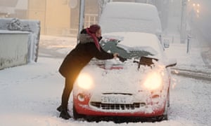 A woman clears snow from her car in Tow Law, County Durham.