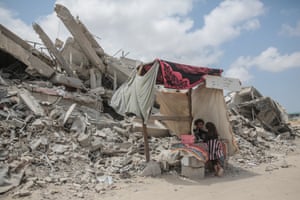 Palestinian children stand near destroyed buildings after Israeli bombardment in Khan Younis, Gaza.