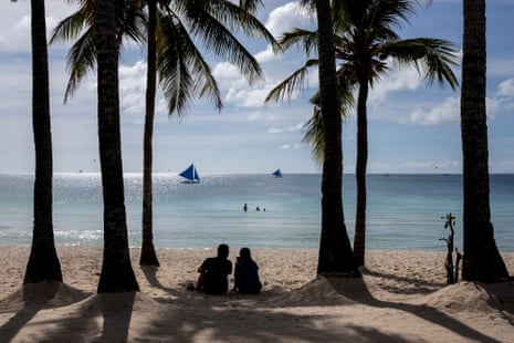 A couple amid palm trees on a beach in the Philippines