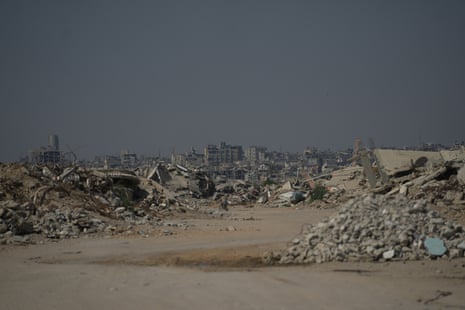 A Palestinian man rides his bicycle by the rubble of buildings that were destroyed in Israeli strikes in Khan Younis, southern Gaza Strip.