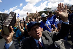 A man holding a Bible prays during a Christian event called March for Jesus in Brasilia, Brazil