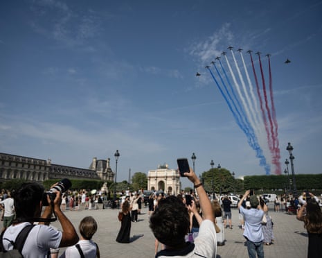 France's Air Force Elite aerobatic flying team "Patrouille de France" (PAF) releases trails of France's national colours as they perform a flyover during the annual Bastille Day military parade.