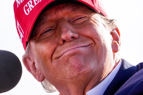 a man in "make america great again" hat smiles