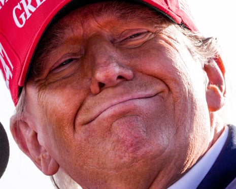 a man in "make america great again" hat smiles