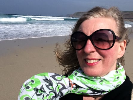 Joanna Moorhead in sunglasses and a colourful scarf smiles at the camera.