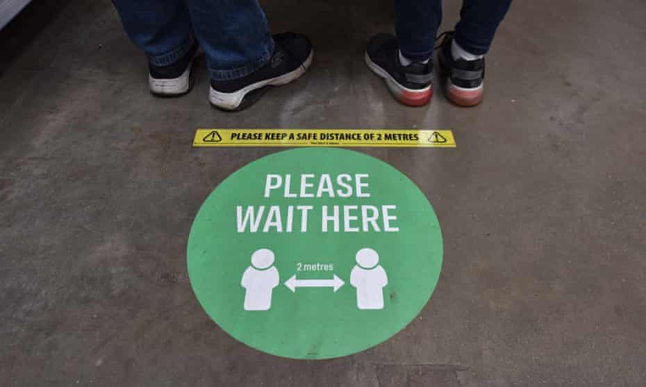 A social distancing sign is seen on the floor.
