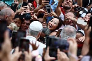 A woman smiles among the crowd as she meets the pope