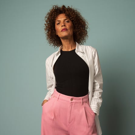 woman in pink trousers, striped shirt and black vest top