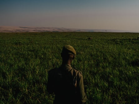 John Mopeto walks across a large grassy plain
