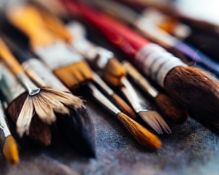 Extreme close-up of watercolour paintbrush bristles fanned out on a dark surface