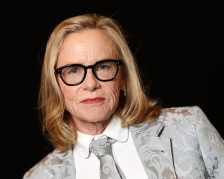 Hollywood veteran Amy Madigan poses in a silver flower-patterned suit and tie.