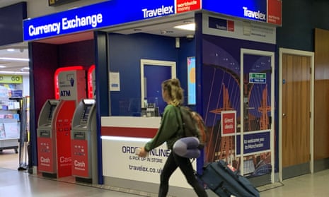 A passenger walks past a Travelex currency exchange at Manchester airport