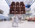 Technicians observe the Nancy Grace Roman Space Telescope's solar panels in a cleanroom
