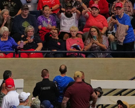 Audience boo as security lead a protester away.