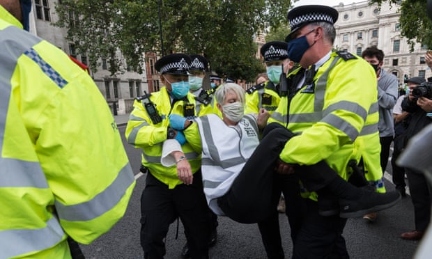 Extinction Rebellion protester being carried by three police officers