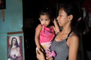 Jessica, 24 and Trista, 2 stand in their neighbours home in a Malabon City, Metro Manila, the Philippines.