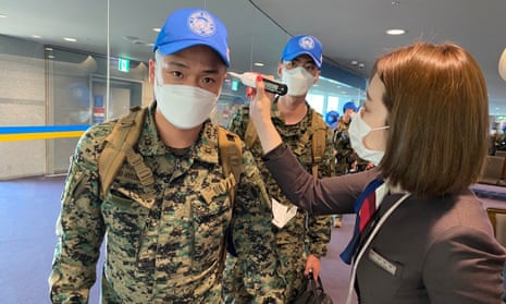South Korean peacekeeping troops are checked for fever before boarding a flight.