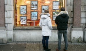 A couple look into an estate agency window