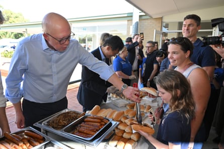 Peter Dutton serves sausages at a campaign rally for volunteers in Mount Pleasant in Perth.