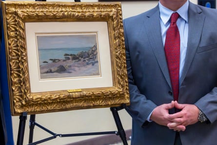 An FBI agent stands next to the 1865 Claude Monet painting Bord de Mer.