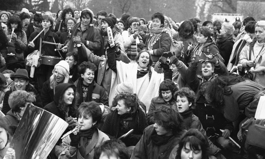 Women peace protesters sit down in the road to block one of the gates to RAF Greenham Common in December 1983.