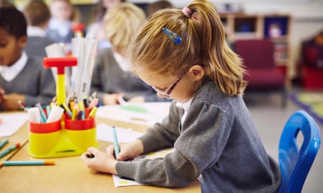 Girl concentrating on drawing in elementary school classroom