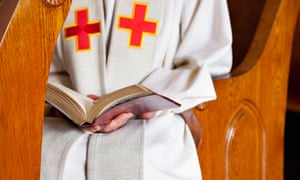 A priest reads a Bible