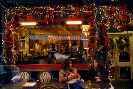 People enjoy festive drinks outside a pub decorated with Christmas lights, in Dublin, Ireland.
