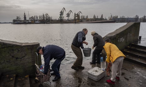Residents of the recently liberated city of Kherson collect water from the Dnipro river bank, near the frontline.