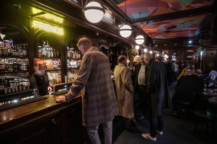 Men and women queueing up at a bar