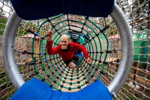 A man climbs through a horizontal tube of netting