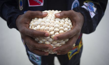 A diver holds an urn containing sand from Mozambique