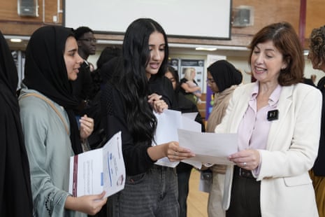 Education secretary Lucy Powell speaks with two students collecting their GCSE results.