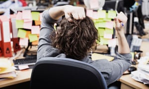 The back head of a worker with a busy desk