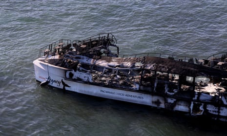 In an aerial view, a boat destroyed by a wildfire sits in the water on August 11, 2023 in Lahaina, Hawaii.