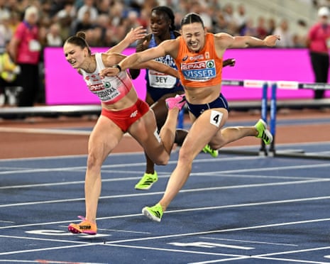 Netherlands’ Nadine Visser crosses the finish line to win the women’s 100m hurdles final alongside second place Poland’s Pia Skrzyszowska.