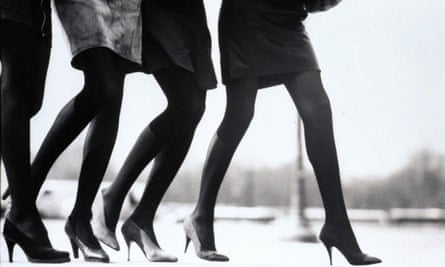 Vogue 1987– Four models, seen from the waist down, walking side by side on a sidewalk; at left, a short dark skirt, by Jean-Paul Gaultier, dark stockings, by Saint Laurent Rive Gauche, and black suede high-heel pumps, by Stephane KÃ©lian; near left, gray suede skirt, dark stockings, and alligator pumps, all by Saint Laurent Rive Gauche; in center, a dark skirt, by Azzedine Alaia, dark stockings , by Pierre Mantoux, and suede pumps, Alaia by Diego Della Valle; at right, dark skirt with wool covered pumps, by Chanel, and dark stockings, by Hanes CREDIT MUST R