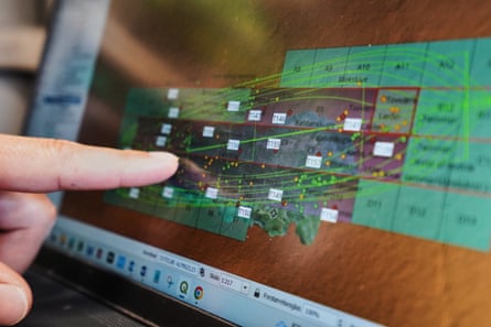 An archaeologist points to a computer screen showing a map of the wreck