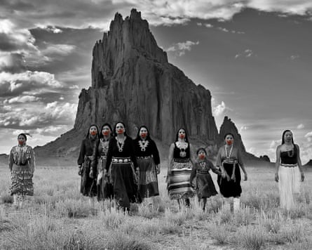 Photo of Indigenous Americans posing successful grassland successful beforehand of a ample stone formation