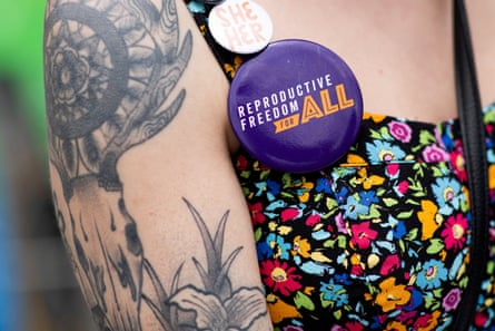 A volunteer wears pins as she gathers signatures for a proposed abortion amendment in Ferndale, Michigan.