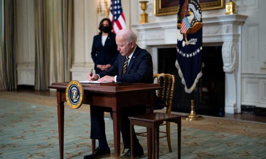 Joe Biden signs an executive order on the economy with Kamala Harris.
