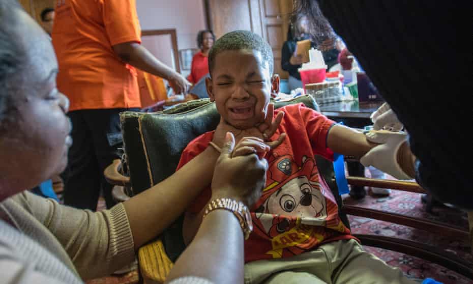 Grant Porter, five, reacts as his mother Ardis Porter tries to comfort him while having his blood drawn to be tested for lead in Flint, Michigan.