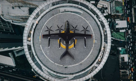 Realistic illustration of a small, black, winged four-rotor aircraft on a circular landing pad, seen from a height, directly above
