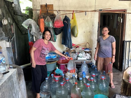 Kadek Siska and mother with plastic water bottles in foreground