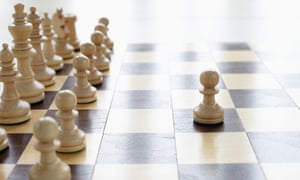 Chessboard with one chess piece facing the others alone