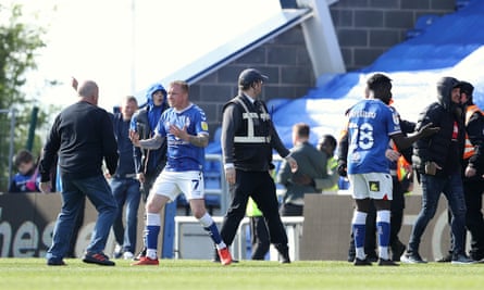 Oldham’s Nicky Adams and Christopher Missilou talk to fans who invaded the pitch at Boundary Park.